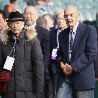 Former Kwansei Gakuin University Fighters head coach Ken Takeda (left) and former Utah State head coach Chuck Mills attend last month’s Koshien Bowl. | KAZ NAGATSUKA