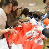 Shoppers snap up \"lucky bags\" filled with mysterious discount merchandise and other New Year\'s holiday bargains at Mitsukoshi department store\'s Nihonbashi outlet on Saturday. | KYODO