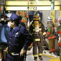 Police and firefighters respond to smoke coming from a ceiling duct in Tokyo\'s Ginza Station on Tuesday morning. Tokyo Metro Co. said the smoke was coming from refuse burning in the ventilation system. No injuries were reported. Operations were temporarily suspended on the entire Hibiya Line, affecting about 68,000 commuters. | KYODO