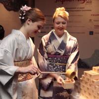Kimono-clad women pour sake into masu (square wooden cup) with hishaku (bamboo ladle). | JAPAN NIGHT ORGANIZATION COMMITTEE