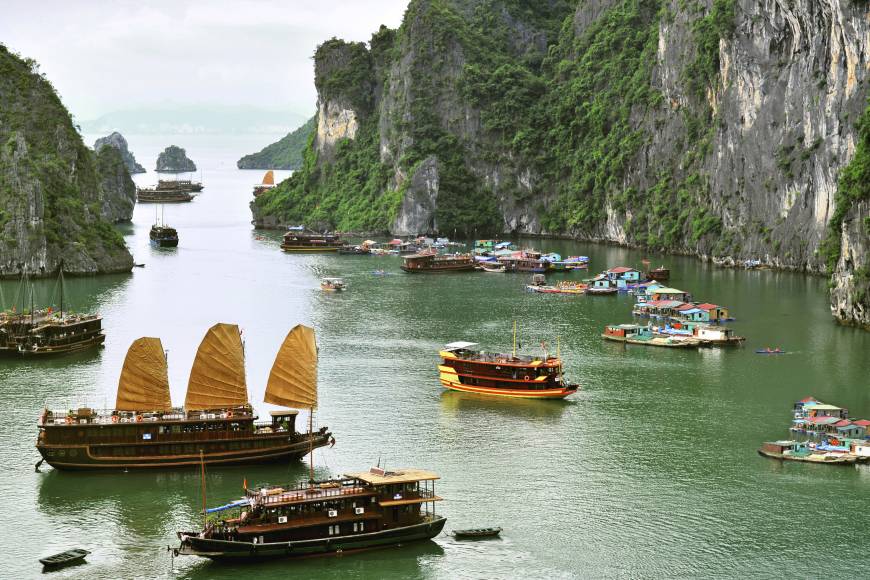 Junks sail around Ha Long Bay among spectacular karst formations and isles.