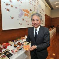 Noriaki Nakajima, executive director of the Rice Stable Support Organization (Public Interest Incorporated Association) poses with an ekiben (station lunch box) during an event celebrating the 130th anniversary of ekiben, for foreign press in Japan, titled \"The Appeal of \'Ekiben\' and \'Rice\' Japanese Staple diet.\" | YOSHIAKI MIURA