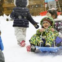 Kindergartners enjoy a sleigh ride in the city of Yamagata on Tuesday after the area was hit by the season\'s first heavy snowfall. Hokkaido, the Tohoku region and areas along the Sea of Japan were expected to see heavy snow and high tides through Wednesday. | KYODO