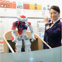 A humanoid robot guide, Nao, seen at Haneda airport on Tuesday, offers information about departures and the weather. | JAPAN AIRLINES CO. / KYODO