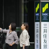 People stand outside a Sumitomo Mitsui Banking Corp. branch in Tokyo in this file photo. | BLOOMBERG