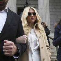 Tangled web: Pop star Kesha Sebert (center) leaves the New York State Supreme Court last week after the court rejected an injunction against the singer\'s recording contract that binds her to an alleged abuser, music producer Lukasz \"Dr. Luke\" Gottwald. | AP