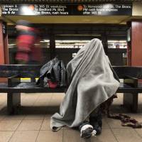 A man rests under a blanket while sitting on a bench in a New York subway station Tuesday. Researchers from Weill Cornell and scientists at the American Museum of Natural History have traced bedbugs through the city’s subway system and discovered a genetic diversity among the bloodsucking creatures. Bedbug genome mapped via NYC subway DNA traces; roaches next