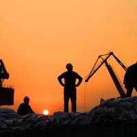 Workers load imported goods at a port in Nantong, Jiangsu province, on Feb. 24. | REUTERS