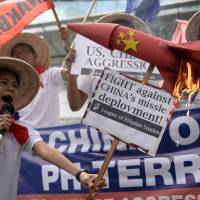 Student activists burn a mock missile during a protest in front of the Chinese Consulate in Manila on Feb. 19. The protesters denounce China\'s deployment of surface-to-air missile system on Woody Island, part of the Paracel chain  also claimed by Taiwan and Vietnam. | AFP-JIJI