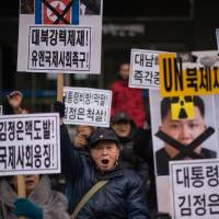 Anti-North Korea activists shout slogans and hold placards during a protest in Seoul on Monday. | AFP-JIJI