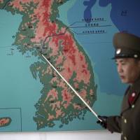 Korean People’s Army Lt. Col. Nam Dong Ho points to a map showing the line that separates the two Koreas in Panmunjom at the Demilitarized Zone (DMZ) on Monday in Panmunjom, North Korea. Nam told The Associated Press that tensions have increased significantly along the Demilitarized Zone since North Korea conducted its nuclear test and rocket launch. He said he could not comment on operational details, but added: “The reality is that it is touch and go.” North Korean officer says tensions rising at DMZ, situation 'touch and go'