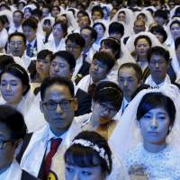 Newlywed couples attend a mass wedding ceremony of the Unification Church at Cheongshim Peace World Centre in Gapyeong, South Korea, on Saturday | REUTERS