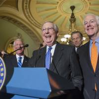 Senate Majority Leader Mitch McConnell, flanked by fellow Republicans, laughs while meeting with reporters on Capitol Hill in Washington Tuesday following a closed-door policy meeting. | AP