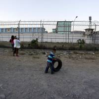 A child plays with a tire outside the Topo Chico prison in Monterrey, Mexico, Feb. 11. Mexican prison where riot claimed 49 held vast luxuries