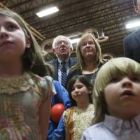 Democratic presidential candidate Sen. Bernie Sanders (center) watches the for results with his wife, Jane during a primary night party at Concord High School on Tuesday in Concord, New Hampshire. | AP