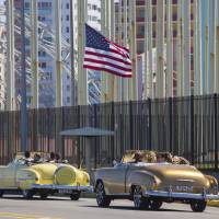Tourists ride vintage American convertibles as they pass by the United States Embassy in Havana Thursday. | AP