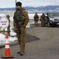 FBI agents man an entry as Harney County residents protest the FBI\'s presence at the Burns Municipal Airport in Burns, Oregon, Sunday. | REUTERS