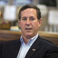 Former Pennsylvania Sen. Rick Santorum meets with voters in Greenfield, Iowa, on Jan. 19. Santorum said Wednesday he is suspending his second bid for the White House. | AP