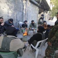Rebel fighters of al-Jabha al-Shamiya (Levant Front) warm themselves around a fire near the justice palace in the old city of Aleppo, Syria, Jan. 28. | REUTERS