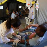Patients receive treatment at a medical mobile unit in the Brazlandia neighborhood of Brasilia Wednesday. The medical unit is in place to attend those who have been affected by diseases transmitted by the Aedes aegypti mosquito, like dengue, malaria and Zika. | AP