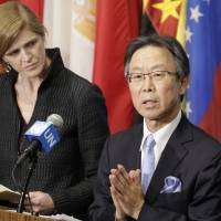Japanese Ambassador to the United Nations Motohide Yoshikawa speaks to the media as U.S. Ambassador Samantha Power listens following an emergency meeting of the Security Council on Sunday after North Korea launched a rocket. | AP