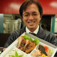 Etsushi Ohashi shows a bento boxed meal his company will start selling at the Okazaki service area. | CHUNICHI SHIMBUN