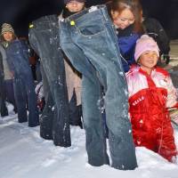 Participants put frozen jeans in the snow in Sarabetsu, Hokkaido, on Sunday. The tongue-in-cheek event was a bid for a Guinness World Record. | KYODO