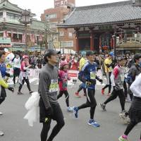 Runners pass the Kaminarimon gate of Sensoji Temple in Asakusa in the 2015 Tokyo Marathon. | KYODO