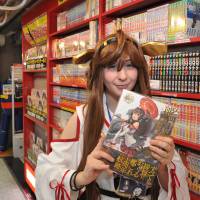 An Italian sales clerk who calls herself Vivi holds a used comic book at a Mandarake store at the Nakano Broadway complex. | YOSHIAKI MIURA