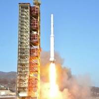 A TV grab from Korean Central Television shows a North Korean rocket lift off from its launchpad in Dongchang-ri Sunday morning. | AFP-JIJI