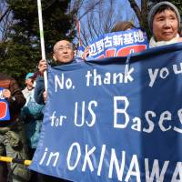 People hold up banners at a rally in front of the Diet on Sunday as they listen to a protester speak out against the long-delayed project to move Futenma air base elsewhere in Okinawa. Diet surrounded by 28,000 as synchronized protests in Japan rip Futenma base move in Okinawa