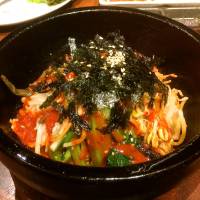 Most evenings, the majority of the seats along the counter are likely to be occupied by solo diners, many of them women picking delicately at their bibimbap rice (above) or chilled reimen noodles. | ROBBIE SWINNERTON