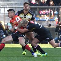 The Sunwolves\' Akihiko Yamada (left) is tackled by the Lions\' Jaco van der Walt on Saturday. | AFP-JIJI