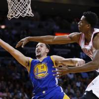 Golden State’s Klay Thompson puts up a shot against Miami’s Hassan Whiteside in the first half on Wednesday night. Warriors top Heat to go 51-5