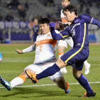 Sanfrecce Hiroshima\'s Kohei Shimizu (right) crosses the ball during last week\'s Asian Champions League game against China\'s Shandong Luneng. | KYODO