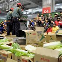 Wholesalers conduct their first auction at a new fruit and vegetables wholesale market in the city of Fukuoka on Friday. The market, which opened earlier in the day, aims to become an export base for Asia in addition to a hub for the domestic market. | KYODO