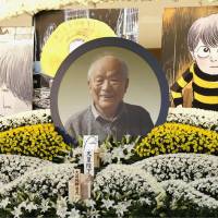 A photo of late manga artist Shigeru Mizuki anchors an altar decorated with flowers and an illustration of his popular character Gegege no Kitaro during a farewell ceremony at a funeral hall in Minato Ward, Tokyo, on Sunday. Mizuki died at the age of 93 in November. | KYODO