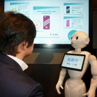 A SoftBank Pepper robot pitches cellphone items during a demonstration Tuesday in Chuo Ward, Tokyo. | KYODO
