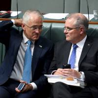 Australian Prime Minister Malcolm Turnbull (left) speaks with Australian Treasurer Scott Morrison during Question Time in the House of Representatives at Parliament House in Canberra, Australia, Thursday. | REUTERS