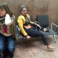 Two women are seen wounded after explosions rocked Brussels airport on Tuesday. | AP