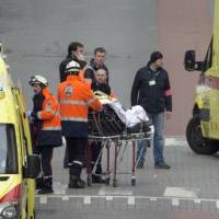 Emergency services evacuate a victim by stretcher after a explosion in a main metro station in Brussels rocked the Brussels airport and the subway system on Tuesday, killing at least 13 people and injuring many others. | AP