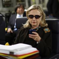 Then-Secretary of State Hillary Clinton checks her Blackberry from a desk inside a C-17 military plane upon her departure from Malta bound for Tripoli in 2011. Clinton\'s work-related emails from her private account are now public, a ledger longer than 52,000 pages detailing her tenure as America\'s top diplomat while failing to resolve questions about how she and her closest aides handled classified information. | AP