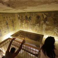 Tourists look at the tomb of King Tut as it is displayed in a glass case at the Valley of the Kings in Luxor, Egypt, in a file photo taken on Nov. 5, 2015. Egypt’s Antiquities Minister Mamdouh el-Damaty said Thursday that analysis of scans of King Tut’s burial chamber has revealed two hidden rooms that could contain metal or organic material. Possible 'discovery of century' as Japan radar expert finds two hidden chambers in King Tut's tomb