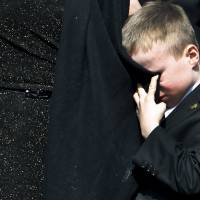 Doug Ford Jr. wipes a tear with his mother’s dress outside St. James Cathedral as the hearse leaves carrying his father. former Mayor Rob Ford, in Toronto Wednesday. Rob Ford 'the mayor of heaven now' as family, Toronto mourn