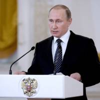 Russian President Vladimir Putin presides at a ceremony presenting state awards to military personnel who fought in Syria at the Kremlin on Thursday. He said Russia could ramp up its military presence there within \"several hours\" if needed. | AFP-JIJI