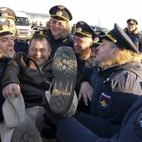 A pilot is thrown in the air by colleagues after returning from Syria at a Russian air base in Primorsko-Akhtarsk, southern Russia, on Wednesday. The Kremlin ordered a surprise partial drawdown after a five-and-a-half month air campaign. | AP