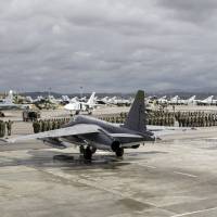 Russian and Syrian servicemen line up near military jets during a ceremony dedicated to the withdrawal of Russian troops from Syria at the Hmeymim air base on Syria on March 15. | REUTERS