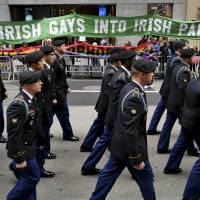 In this March 17, 2015, photo, marchers walk past a group of protesters seeking the inclusion of LGBT groups during the St. Patrick’s Day Parade in New York. New York’s St. Patrick’s Day Parade steps off Thursday, March 17, 2016, with hopes of closing a long chapter of controversy over gay inclusion in the largest and oldest U.S. celebration of Irish heritage. To gay groups, St. Patrick's parade ends an era of exclusion