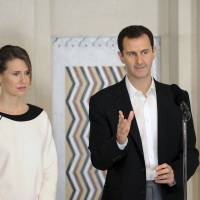 Syrian President Bashar Assad stands next to his wife, Asma, as he addresses injured soldiers and their mothers during a celebration marking Syrian Mother\'s Day in Damascus on Monday. | REUTERS