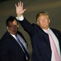 New Jersey Gov. Chris Christie is overshadowed by Republican presidential hopeful Donald Trump as they depart a rally Monday in Vienna Center, Ohio. The six remaining White House hopefuls made a frantic push for votes Monday on the eve of make-or-break nominating contests, with Trump\'s Republican rivals desperate to bar his path after a weekend of violence on the campaign trail. | AFP-JIJI